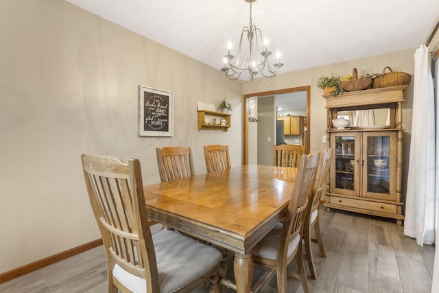 dining room featuring wood-type flooring and an inviting chandelier