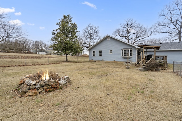 view of yard with a deck and a fire pit