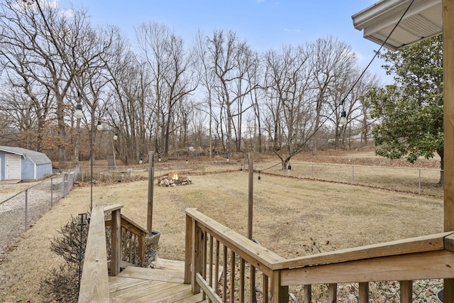 view of yard featuring a wooden deck and a fire pit