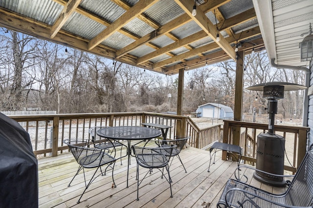 deck with an outbuilding, a garage, and a grill