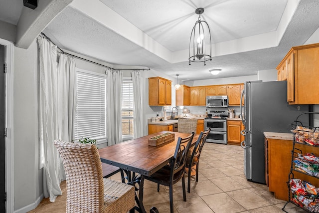 dining space featuring a raised ceiling, sink, a textured ceiling, and light tile patterned floors