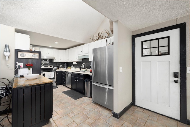 kitchen featuring sink, tasteful backsplash, a textured ceiling, stainless steel appliances, and white cabinets