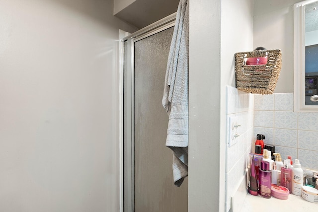 bathroom featuring walk in shower and tile walls