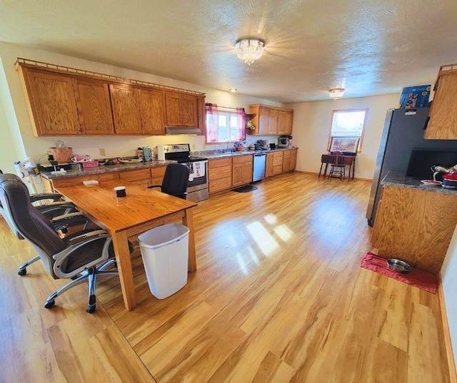 office area with sink, a textured ceiling, and light wood-type flooring