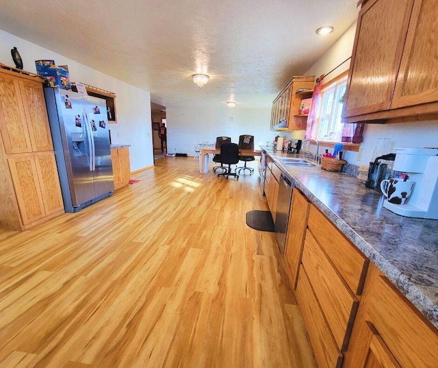 kitchen with stainless steel appliances, sink, and light wood-type flooring