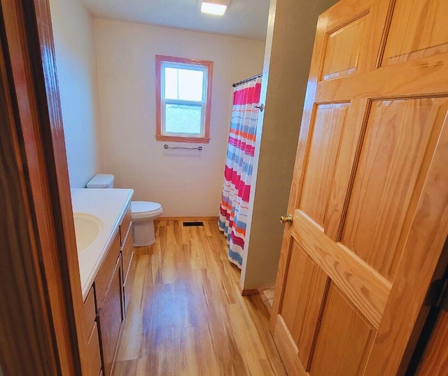 bathroom with vanity, hardwood / wood-style flooring, and toilet