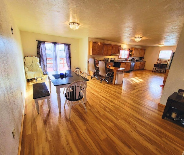 dining area featuring a textured ceiling and light wood-type flooring