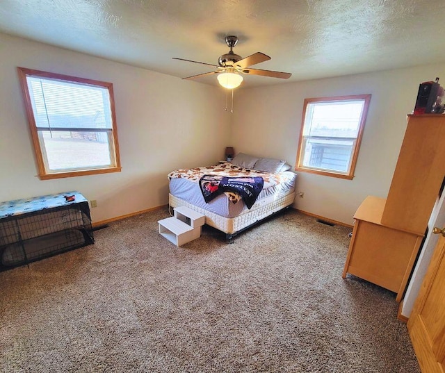 carpeted bedroom featuring ceiling fan and a textured ceiling