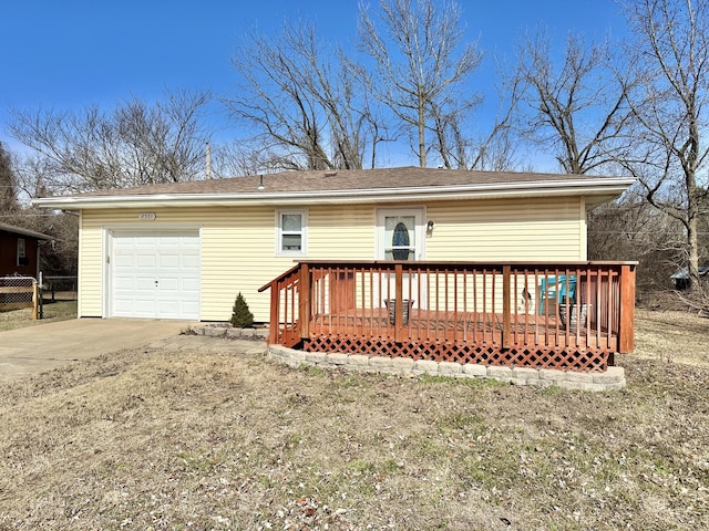 exterior space featuring a garage, a lawn, and a deck