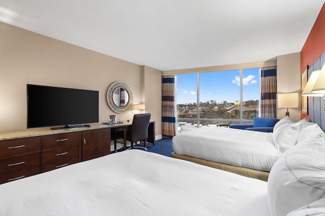 bedroom with expansive windows and dark carpet