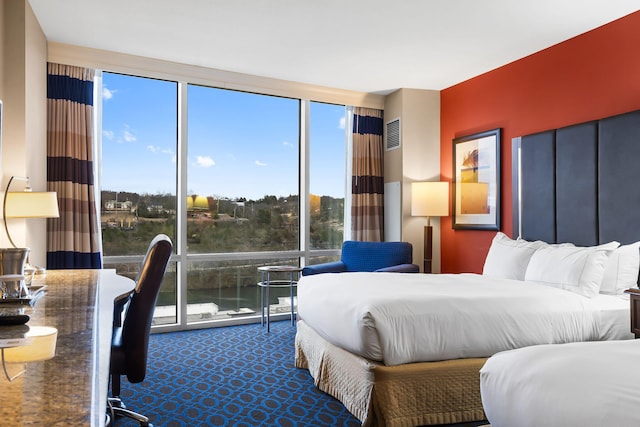 bedroom featuring floor to ceiling windows and carpet floors