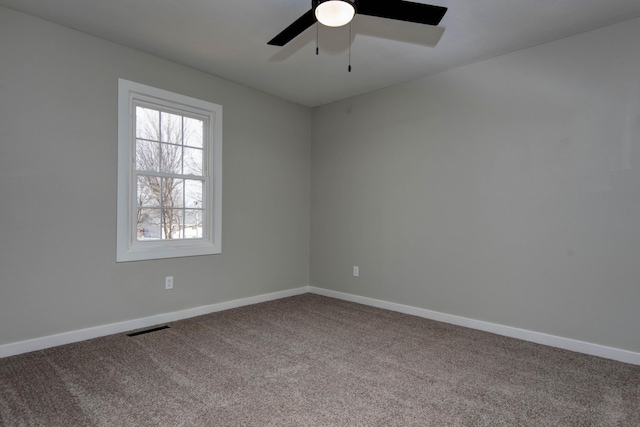 unfurnished room featuring visible vents, baseboards, a ceiling fan, and carpet
