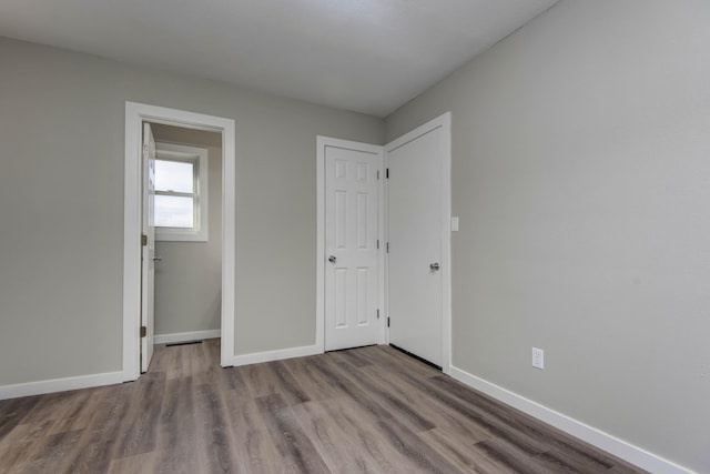 unfurnished bedroom with baseboards and wood finished floors