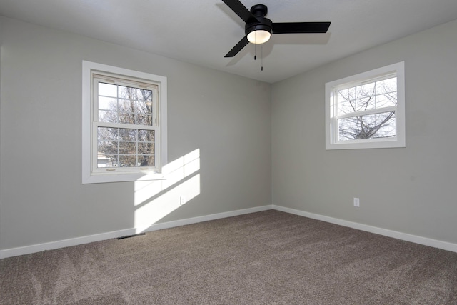 spare room with ceiling fan, baseboards, visible vents, and carpet floors