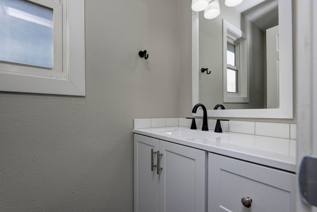 bathroom featuring a textured wall and vanity