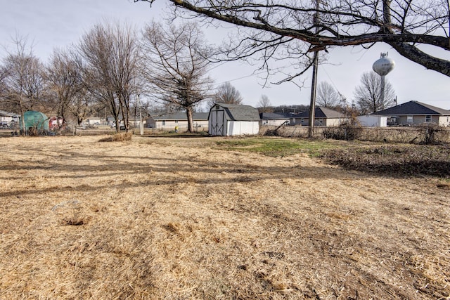 view of yard with a storage shed, fence, and an outbuilding