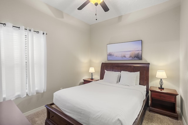 carpeted bedroom with ceiling fan and baseboards