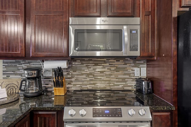 kitchen with dark stone countertops, stainless steel appliances, and decorative backsplash