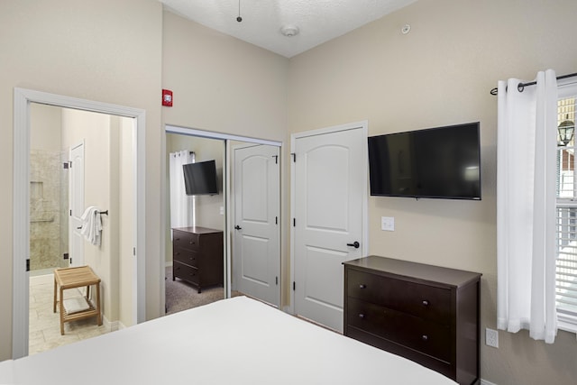 bedroom featuring a closet, a textured ceiling, and ensuite bath