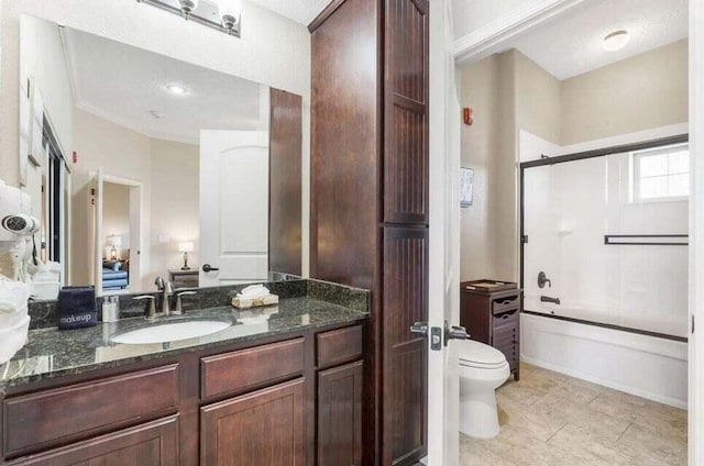 bathroom with combined bath / shower with glass door, vanity, toilet, and tile patterned floors