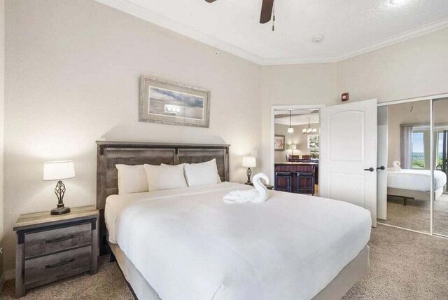 bedroom with carpet floors, a closet, ornamental molding, and ceiling fan