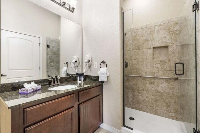 bathroom featuring a shower stall and vanity