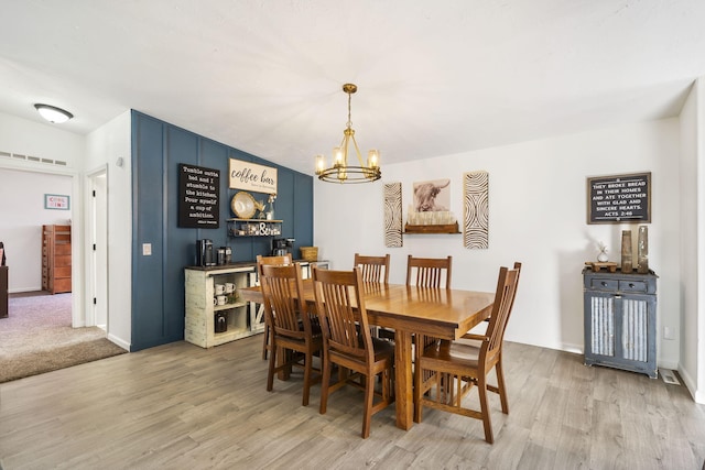 dining area featuring hardwood / wood-style flooring and a notable chandelier