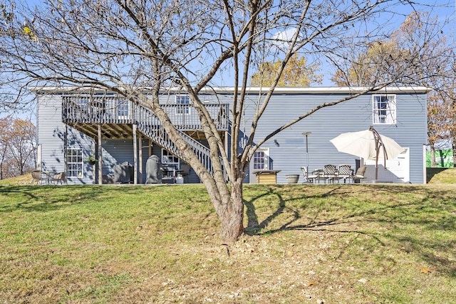 back of house with a wooden deck, a yard, and a patio area