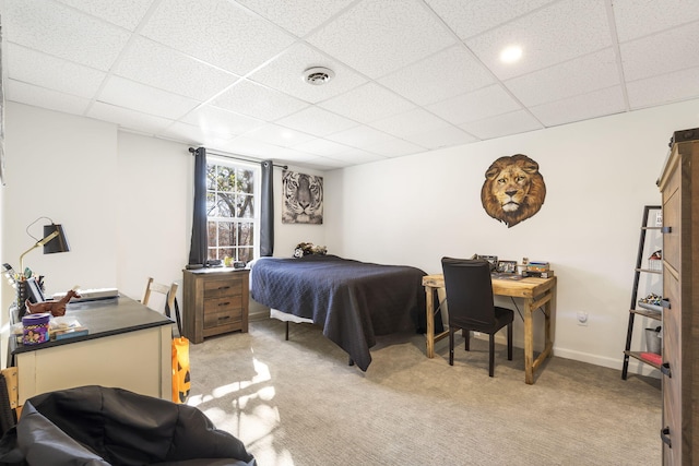 bedroom featuring light carpet and a paneled ceiling