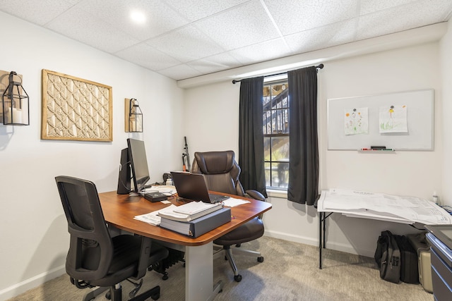 carpeted office with a paneled ceiling