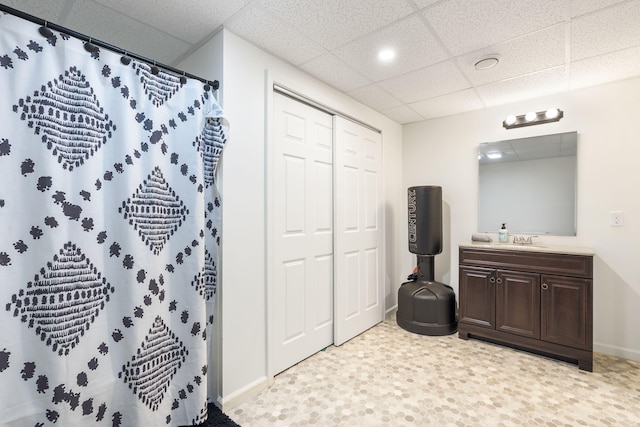 bathroom featuring vanity, a drop ceiling, and walk in shower