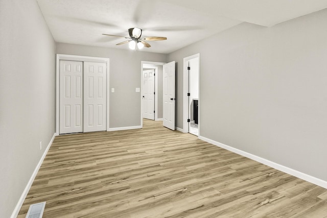 unfurnished bedroom featuring ceiling fan, light hardwood / wood-style floors, and a closet