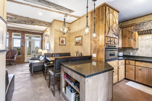 kitchen featuring french doors, stainless steel oven, hanging light fixtures, beamed ceiling, and backsplash