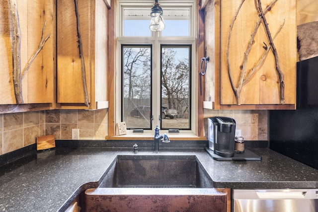 kitchen with tasteful backsplash, sink, stainless steel dishwasher, and decorative light fixtures