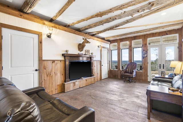 living room featuring beamed ceiling, french doors, and wood walls