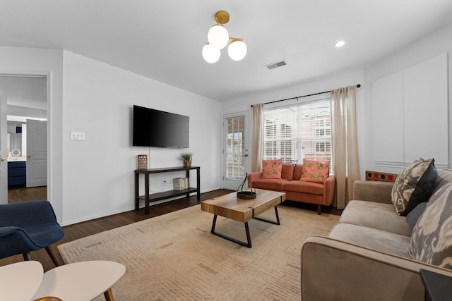 living room with an inviting chandelier and hardwood / wood-style flooring