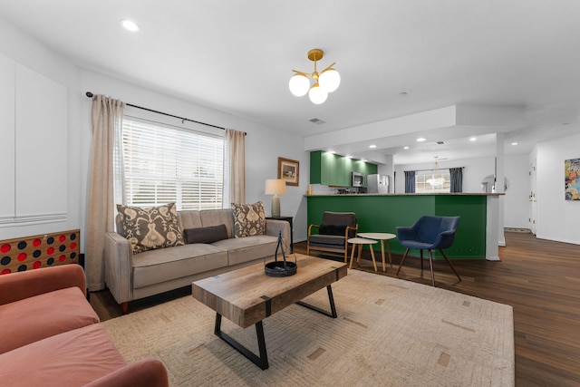 living room with dark wood-type flooring and a chandelier