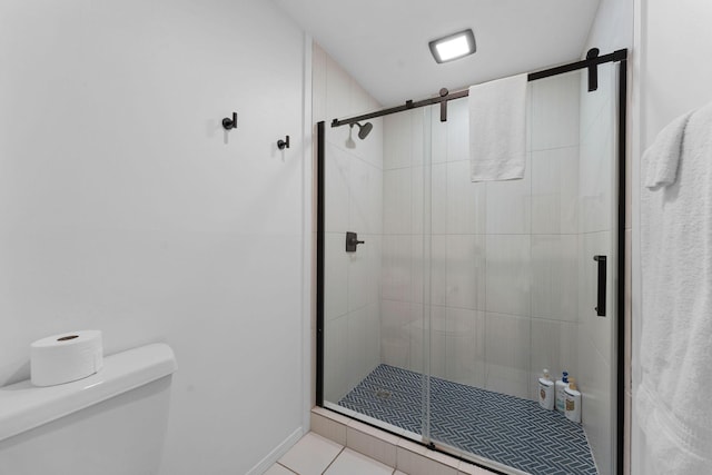 bathroom featuring tile patterned flooring, toilet, and walk in shower