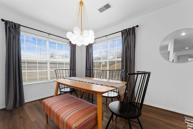 dining space with a notable chandelier and dark hardwood / wood-style flooring