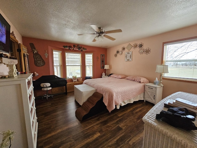 bedroom featuring dark wood-type flooring, a textured ceiling, and ceiling fan