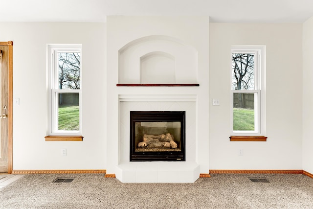 unfurnished living room featuring carpet floors and a wealth of natural light