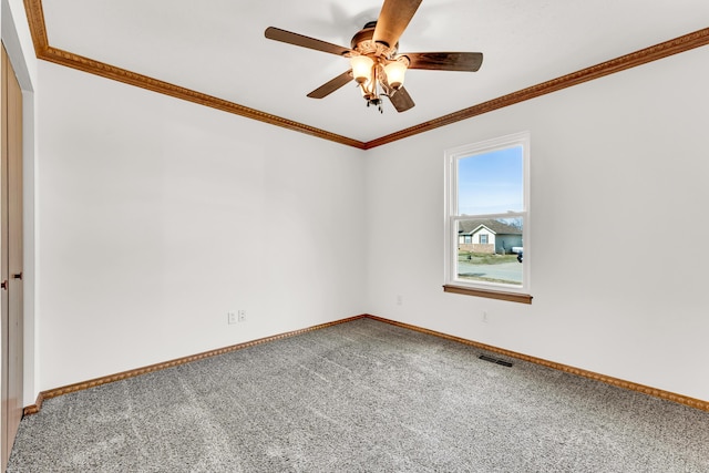 carpeted spare room featuring crown molding and ceiling fan