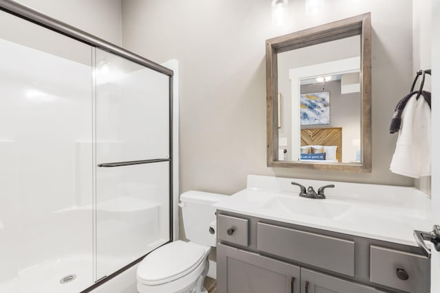 bathroom with vanity, toilet, and a shower with shower door