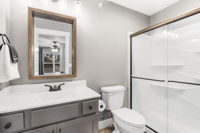 bathroom with an enclosed shower, vanity, and toilet