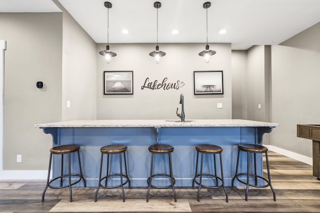 bar with pendant lighting, dark hardwood / wood-style floors, and sink