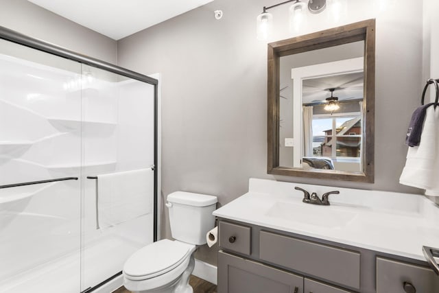 bathroom with a shower with door, vanity, and toilet