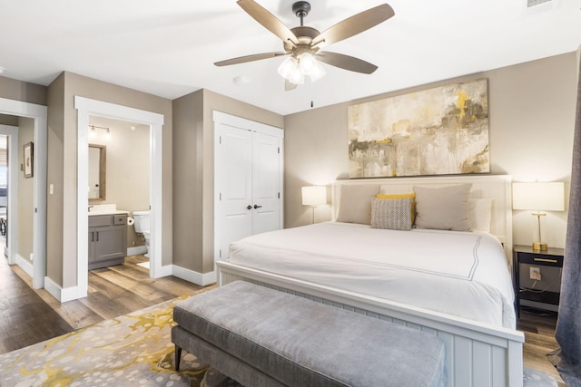 bedroom with wood-type flooring, ensuite bathroom, ceiling fan, and a closet