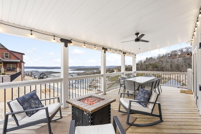 wooden deck featuring ceiling fan and a fire pit