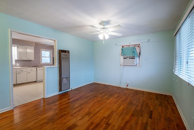 empty room featuring cooling unit, ceiling fan, and light wood-type flooring