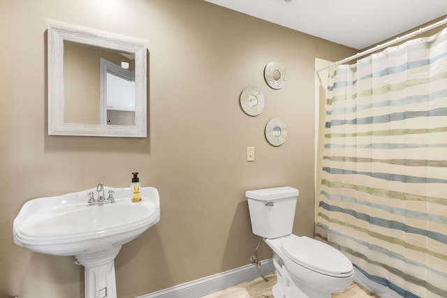 bathroom with hardwood / wood-style flooring, sink, toilet, and a shower with shower curtain